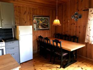 cocina con mesa de madera y nevera blanca en Rauland Hytteutleige, en Rauland