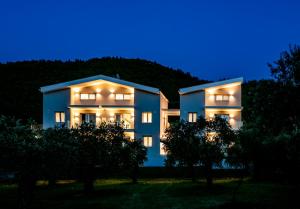 a blue house with lights on in the night at Harmony Thassos suites & Apartments in Skala Rachoniou