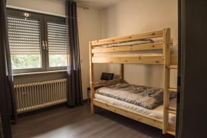 a bedroom with two bunk beds and a window at Ferienwohnung Roos in Klüsserath