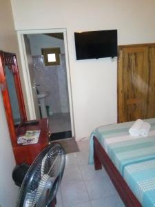 - une chambre avec un lit, un miroir et une télévision dans l'établissement Chez Coumba et Daniel, à Saly Portudal