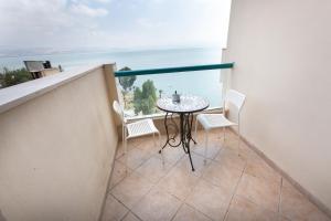 uma varanda com uma mesa e cadeiras e o oceano em Sweet Suite Galilee em Tiberias