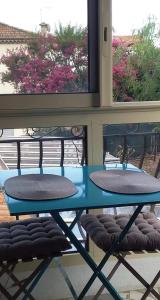 a blue table and chairs in front of a window at Le rêve bleu in Cagnes-sur-Mer