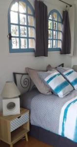 a bedroom with a bed and a table and windows at Le rêve bleu in Cagnes-sur-Mer