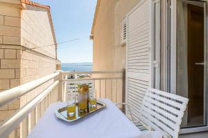 a tray of food sitting on a table on a balcony at Apartments Bezmalinović 2 in Bol