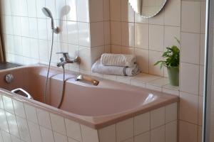 ein Badezimmer mit einer Badewanne mit einem Wasserhahn in der Unterkunft Ferienhaus AM ALTEN POSTHOF in Lieser