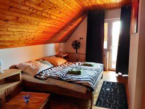 1 dormitorio con cama y techo de madera en Balaton Holiday, en Fonyód