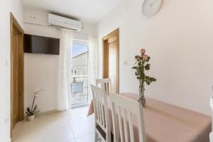a dining room with a table and a vase with a plant at Apartments Bezmalinović 2 in Bol