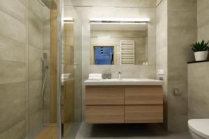 a bathroom with a sink and a shower at Malta Apartament Parking by IMPERO in Poznań