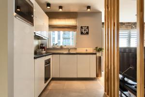 a kitchen with white cabinets and a sink at Malta Apartament Parking by IMPERO in Poznań +15 photos