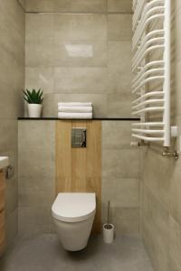 een badkamer met een toilet en handdoeken bij Malta Apartament IMPERO z Parkingiem in Poznań