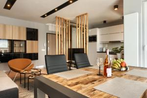 a kitchen and living room with a table and chairs at Malta Apartament Parking by IMPERO in Poznań