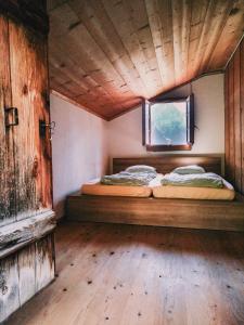 two beds in a room with a window at Mountain Hostel Gimmelwald in Gimmelwald