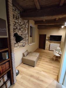 a living room with a couch and a stone wall at Montella 2 in Spoleto