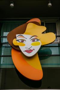 Una gran pintura de una mujer usando un sombrero en Roberta Rosa De Fontana Suites en Rosario