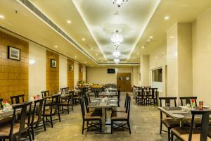 a restaurant with tables and chairs in a room at Quality Inn Ramachandra in Visakhapatnam +8 photos