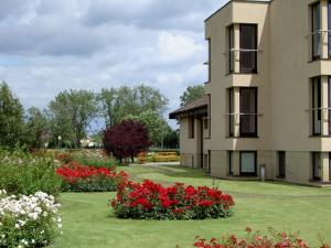 budynek z czerwonymi kwiatami na dziedzińcu w obiekcie Hotel Grodzki w Poznaniu