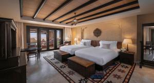 
a hotel room with a large bed and a large window at Anantara Qasr al Sarab Desert Resort in Jurayrah
