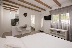 a bedroom with a bed and a table and a desk at Studio apartments Tara in Zadar
