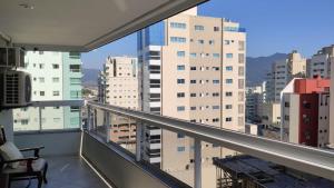 a balcony with a view of a city with buildings at Apartamento confortável em Meia Praia - 200 metros da praia in Itapema