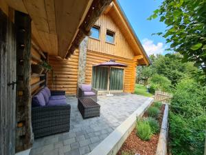 eine Terrasse eines Blockhauses mit einem Sonnenschirm in der Unterkunft Log House Natura in Radovljica