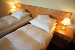 pokój hotelowy z dwoma łóżkami i stołem z lampą w obiekcie Hotel Grodzki w Poznaniu