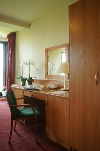 a hotel room with a desk with a mirror and a chair at Hotel Grodzki in Poznań