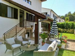 a patio with chairs and a table and an umbrella at Apartments Villa Katana in Poreč