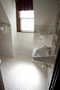 a white bathroom with a sink and a window at Prince of Wales Hotel in Waterton Park