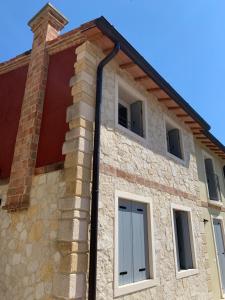 un edificio de ladrillo con ventanas y una puerta en Villavecchia, en Castegnero