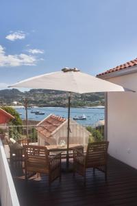 a table and chairs with an umbrella on a balcony at Views and Beds in Pontevedra