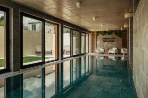 a swimming pool in a house with windows at Penzión Walddorf in Nová Lesná