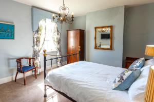 a bedroom with a bed and a mirror and a chair at Durham House Holiday Let, sleeps 26 with Croft and Hay Loft in Sedgefield