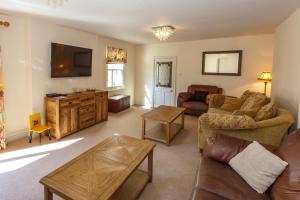 a living room with a couch and a tv at Durham House Holiday Let, sleeps 26 with Croft and Hay Loft in Sedgefield