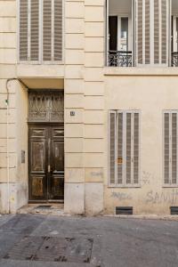 een gebouw met een houten deur op een straat bij La Plume in Marseille