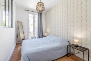 een witte slaapkamer met een bed en een raam bij La Plume in Marseille