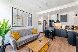 een woonkamer met een bank en een keuken bij La Plume in Marseille
