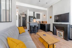 een woonkamer met een bank en een open haard bij La Plume in Marseille