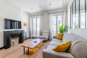 een woonkamer met een bank en een open haard bij La Plume in Marseille