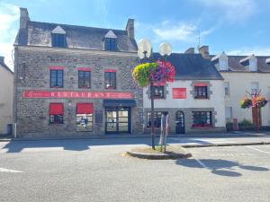 an old stone building with flowers on a street at Le Patio in Évran