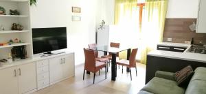 sala de estar con mesa, sillas y sofá en La casetta, en Siena