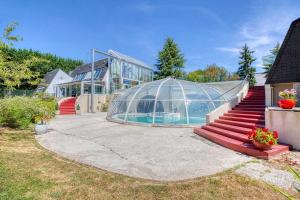 a house with a greenhouse and a swimming pool at CHAMBRE INDEPENDANTE DANS UN PARC in Saint-Roch