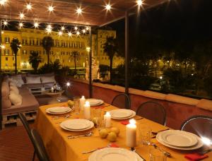 un tavolo con piatti e candele su un balcone di notte di Palermo Magic House a Palermo
