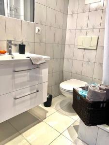 a white bathroom with a sink and a toilet at Chez Coco Apartment 2 Aachen in Aachen