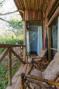 a porch of a cabin with a chair and a window at Chalé Envidraçado no Itaimbezinho in Praia Grande