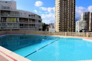 una grande piscina di fronte ad alcuni edifici di Apartment Levante Halcon a Benidorm