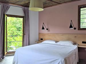Agii SarantaにあるDaria's Home - Seaview Tranquility & Relaxationのベッドルーム(白いベッド1台、窓付)