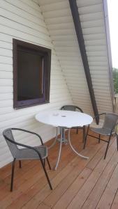 einen Tisch und zwei Stühle auf einer Veranda mit einem TV in der Unterkunft Nijolės sodyba in Aukštadvaris