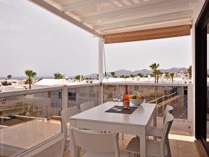 una sala da pranzo con tavolo e sedie bianchi sul balcone di Villa Zonzamas a Puerto del Carmen