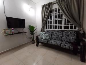 a living room with a couch and a flat screen tv at Sri Makmur Pontian Homestay in Pontian Besar