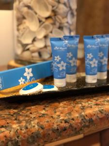 聖胡安的住宿－EM Royalle Hotel & Beach Resort，盘子,盘子上放着三个蓝色的杯子和蛋糕